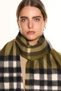 A stylised artistic arrangement of red and gold thistles surrounding a Thomson Red cashmere scarf.