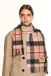 A folded red tartan cashmere scarf in a luxury signature gift box.