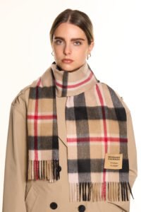 An elegant lifestyle shot of a woman in Shanghai wearing a classic Scottish check scarf, blending Eastern and Western aesthetics.