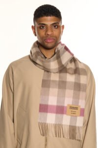 A high-fashion editorial shot of a red tartan cashmere scarf.